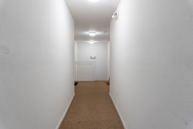 hallway with carpet floors and baseboards