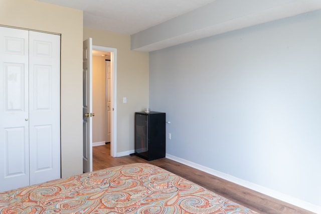 bedroom featuring baseboards, a closet, and wood finished floors