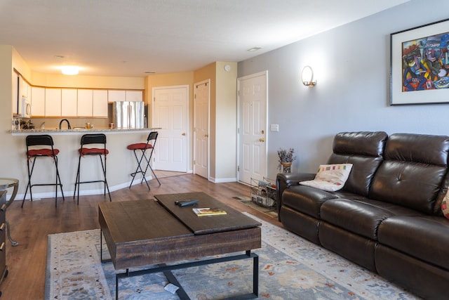 living room with baseboards and dark wood-style flooring
