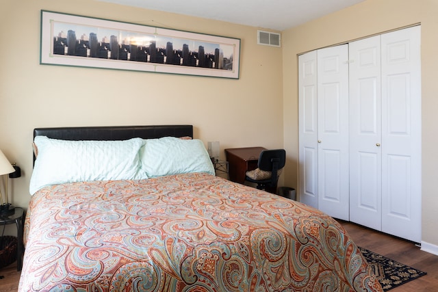 bedroom with a closet, wood finished floors, and visible vents