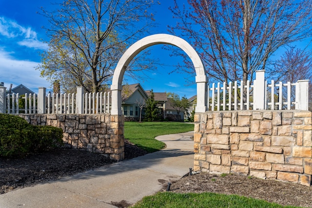 view of community featuring a lawn and fence