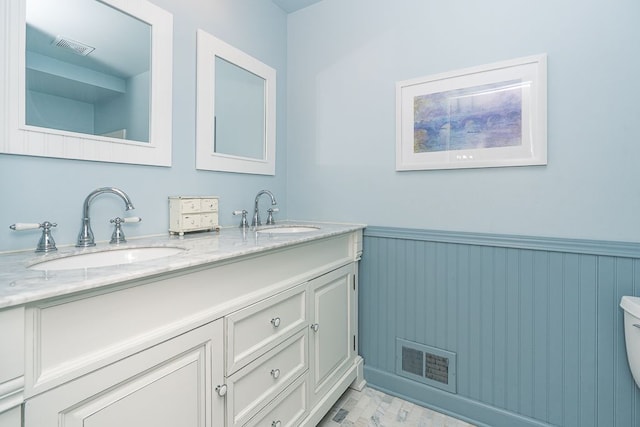 full bathroom featuring visible vents, wainscoting, and a sink