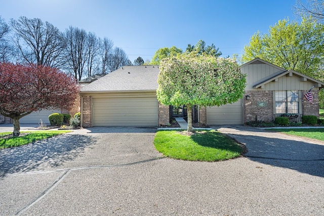 view of front of property featuring a garage, driveway, and brick siding