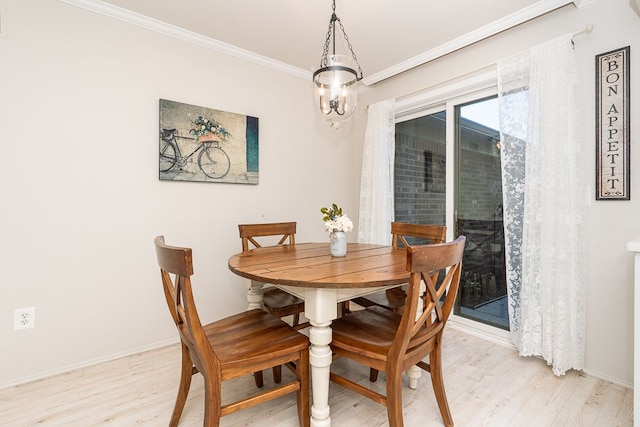 dining space with crown molding, light wood-style flooring, and baseboards