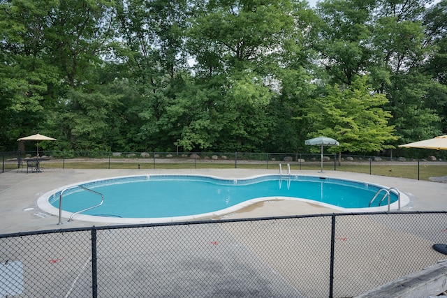 community pool featuring fence and a patio area