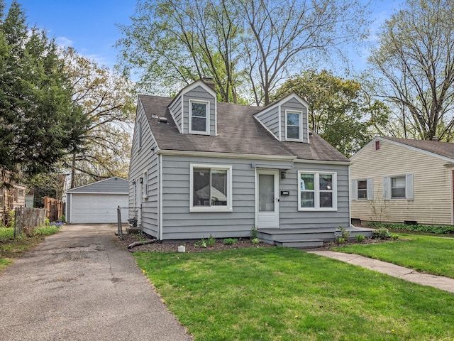 cape cod house featuring fence, roof with shingles, a front lawn, a detached garage, and an outbuilding