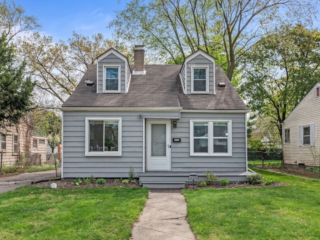 cape cod home with a shingled roof, a front lawn, fence, and a chimney