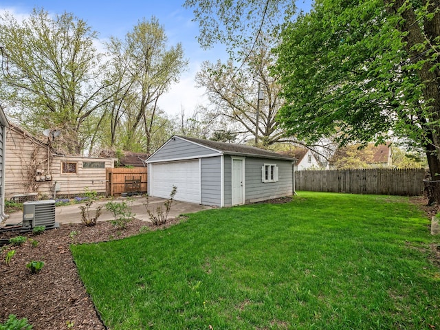 view of yard featuring a garage, an outbuilding, cooling unit, and a fenced backyard