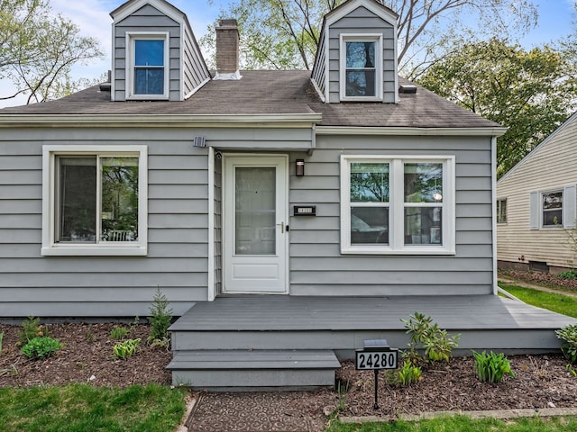 view of front of house with a wooden deck and a chimney