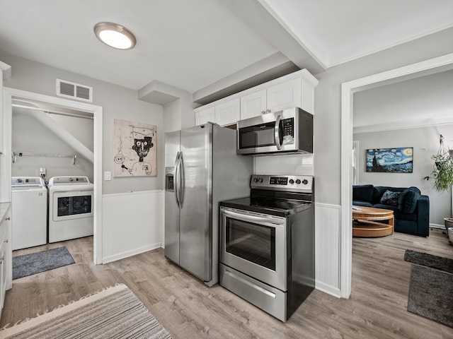 kitchen featuring visible vents, appliances with stainless steel finishes, white cabinets, light wood finished floors, and washer and dryer
