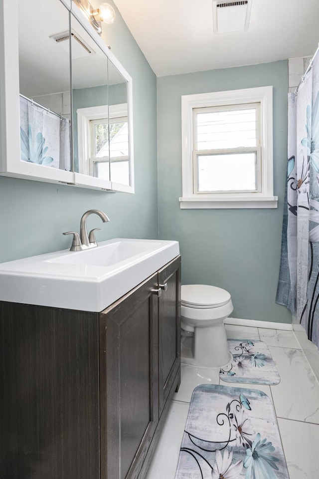 bathroom with visible vents, a healthy amount of sunlight, and vanity