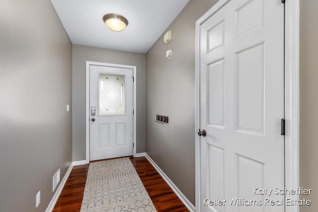 doorway to outside with visible vents, dark wood finished floors, and baseboards