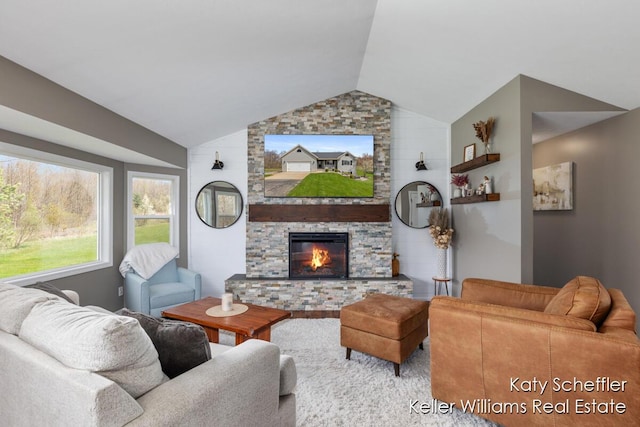 living room with vaulted ceiling and a stone fireplace