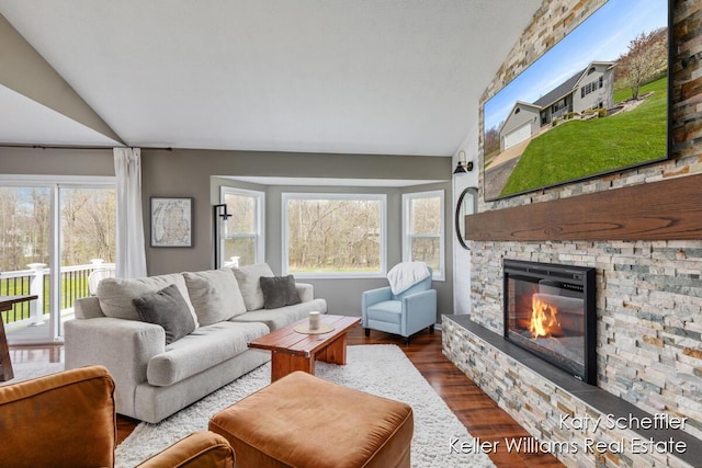 living room with a stone fireplace, dark wood finished floors, and vaulted ceiling