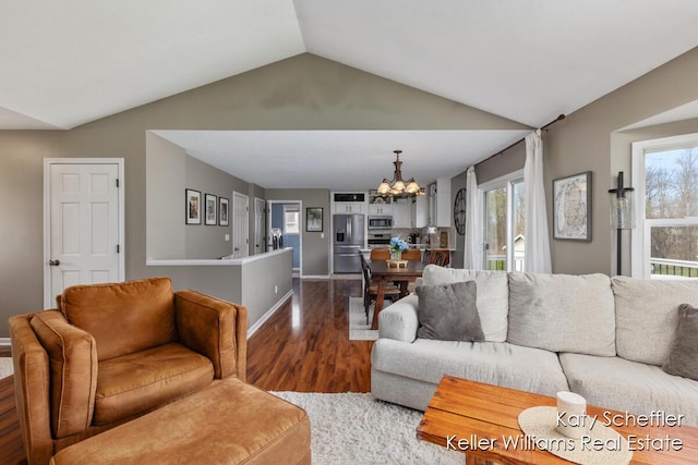 living room with baseboards, a chandelier, vaulted ceiling, and dark wood-type flooring