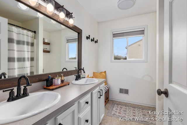 bathroom featuring a sink, tile patterned flooring, double vanity, and visible vents