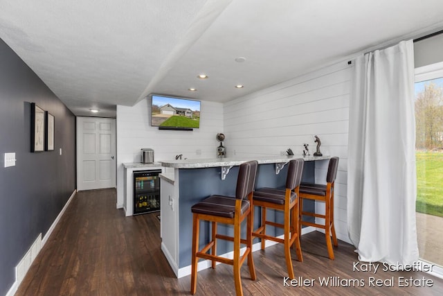 bar with wood walls, baseboards, wine cooler, visible vents, and dark wood-style floors