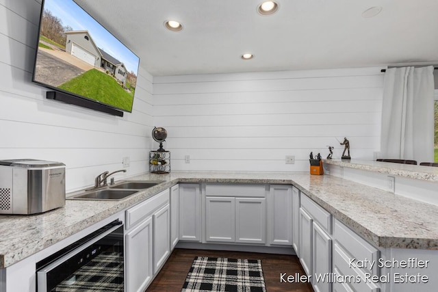 kitchen featuring recessed lighting, a sink, dark wood finished floors, and wine cooler