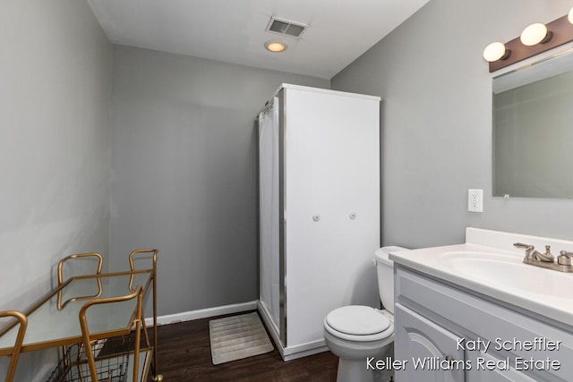 full bathroom with vanity, toilet, wood finished floors, and a stall shower
