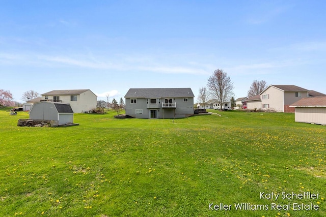 view of yard with a residential view, an outbuilding, and a storage unit