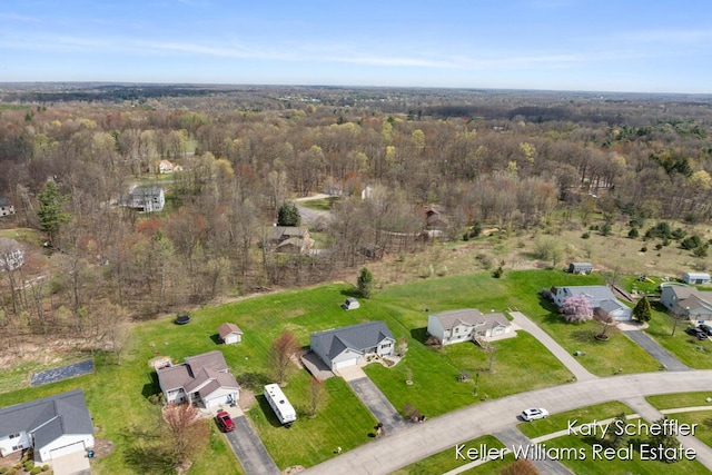 bird's eye view with a wooded view