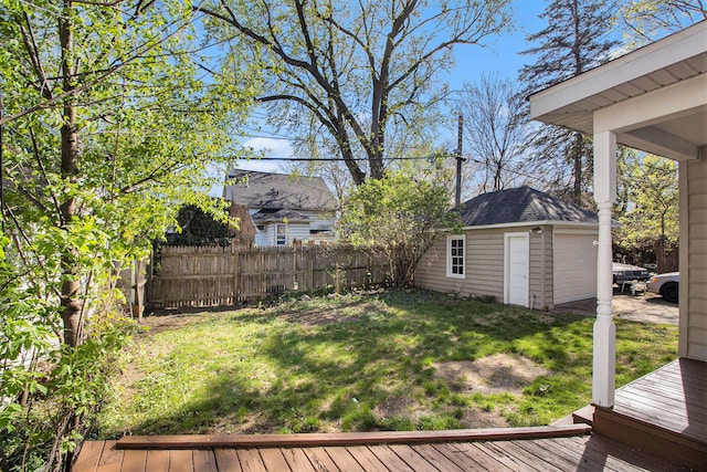view of yard with an outdoor structure, a garage, fence, and a wooden deck