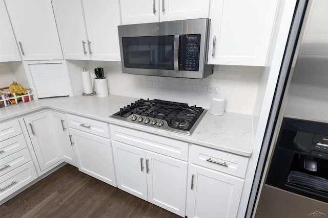 kitchen featuring white cabinets, stainless steel appliances, dark wood-style flooring, and tasteful backsplash