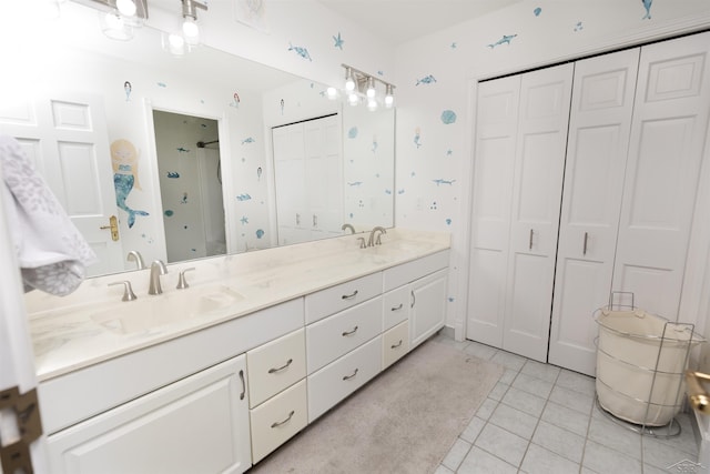 full bath featuring a closet, a sink, tile patterned floors, and double vanity