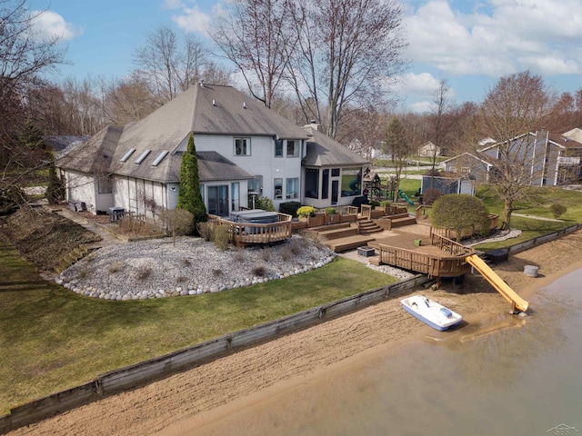 rear view of property featuring a yard and a deck
