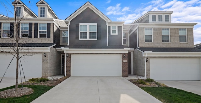 multi unit property with brick siding, a garage, and driveway