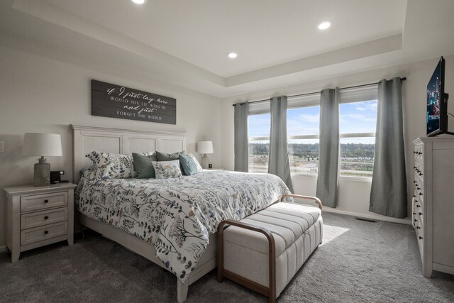 bedroom with visible vents, baseboards, recessed lighting, a tray ceiling, and carpet