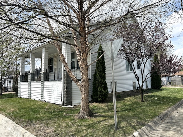 view of property exterior with a lawn and covered porch