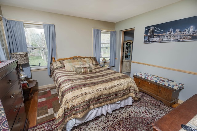 bedroom featuring baseboards and multiple windows