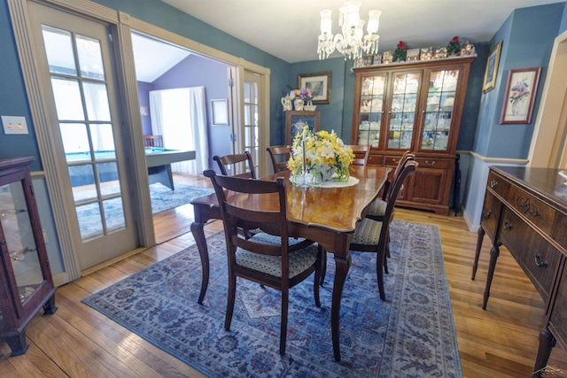 dining room featuring an inviting chandelier, plenty of natural light, light wood-style floors, and french doors