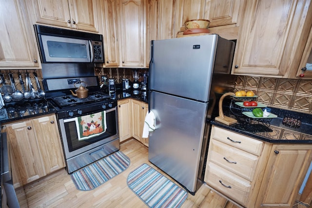kitchen with light wood-style floors, light brown cabinetry, backsplash, and stainless steel appliances