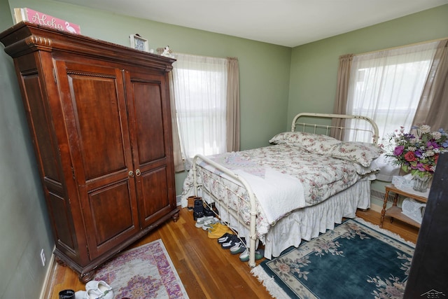 bedroom featuring wood finished floors and multiple windows