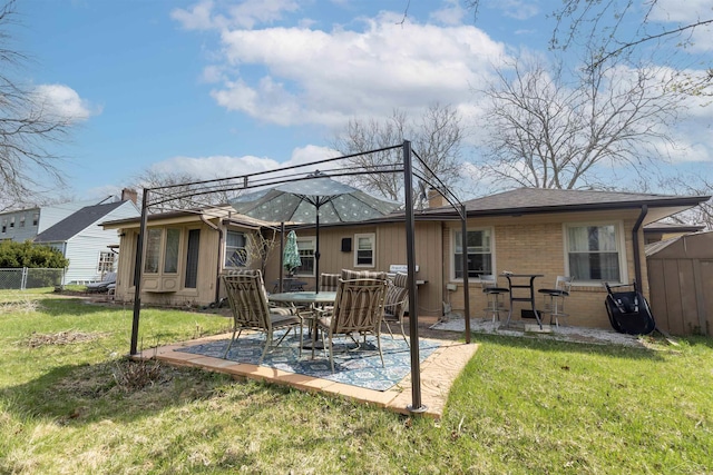 rear view of house featuring a yard, a patio, fence, and brick siding