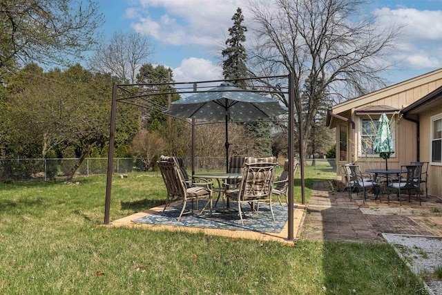 view of yard featuring outdoor dining area, a patio area, and fence