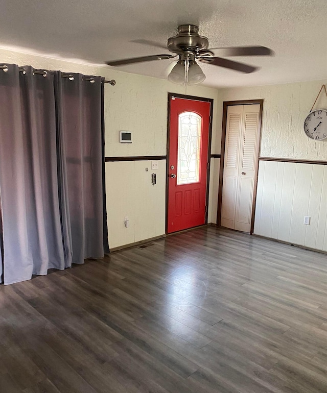 entryway with ceiling fan, wainscoting, a textured ceiling, and wood finished floors