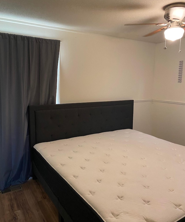 bedroom with visible vents, ceiling fan, and wood finished floors