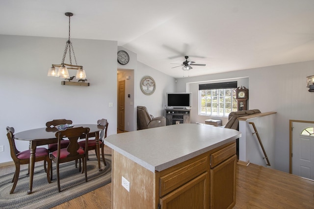 1077 Sun Valley Ln, Allegan, MI 49010 - kitchen with wood finished floors, a kitchen island, ceiling fan, light countertops, and vaulted ceiling