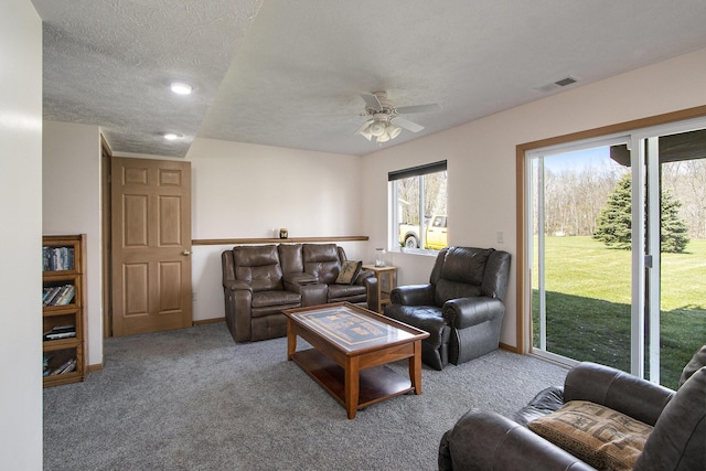 1077 Sun Valley Ln, Allegan, MI 49010 - living area featuring a ceiling fan, a textured ceiling, visible vents, baseboards, and carpet flooring