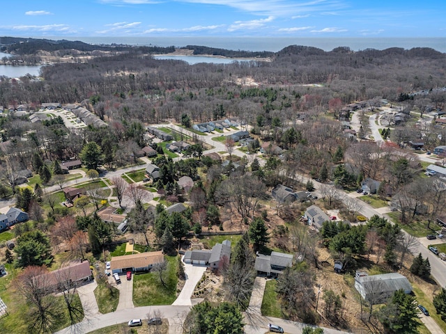 birds eye view of property featuring a water view, a view of trees, and a residential view