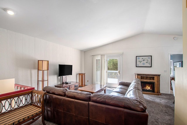carpeted living room with a glass covered fireplace and vaulted ceiling