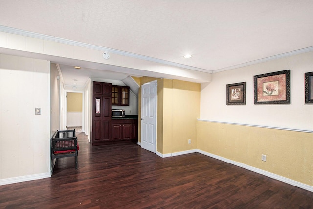 interior space with baseboards, ornamental molding, and dark wood-style flooring