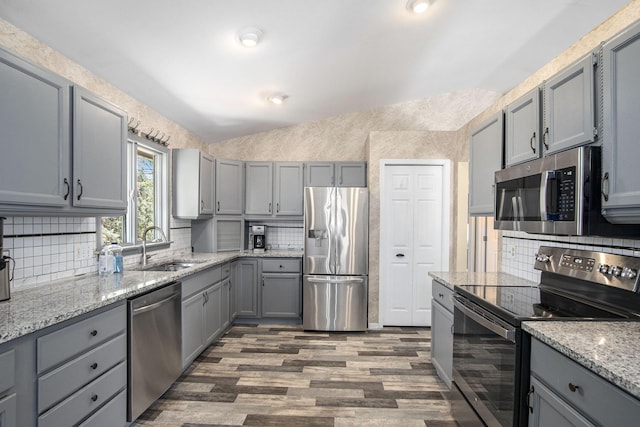 kitchen with backsplash, dark wood-style flooring, appliances with stainless steel finishes, and gray cabinets