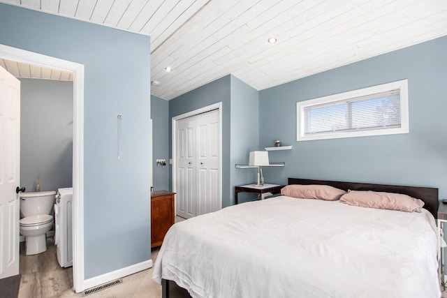 bedroom with baseboards, wood finished floors, visible vents, wood ceiling, and a closet