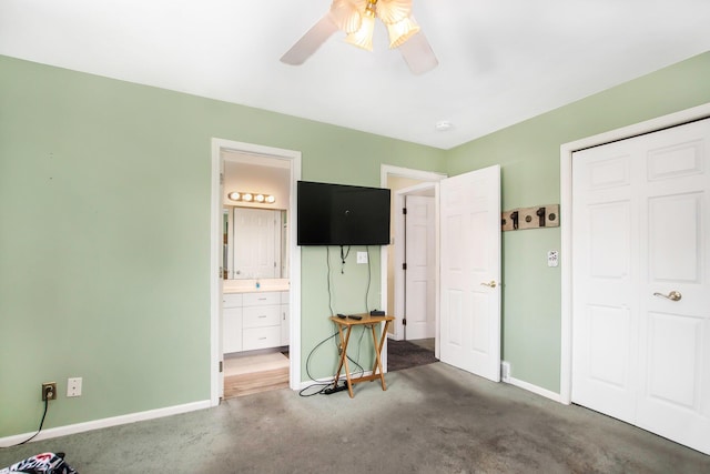 bedroom with carpet floors, baseboards, a ceiling fan, and ensuite bath
