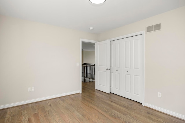 1685 E Wattles Rd, Troy, MI 48085 - unfurnished bedroom featuring a closet, wood finished floors, visible vents, and baseboards