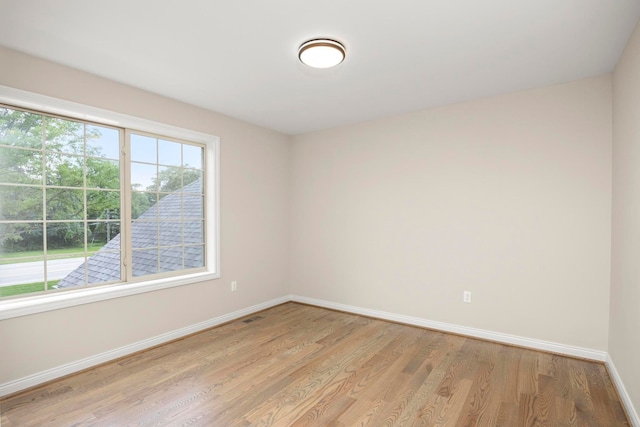 empty room with baseboards and light wood-style flooring
